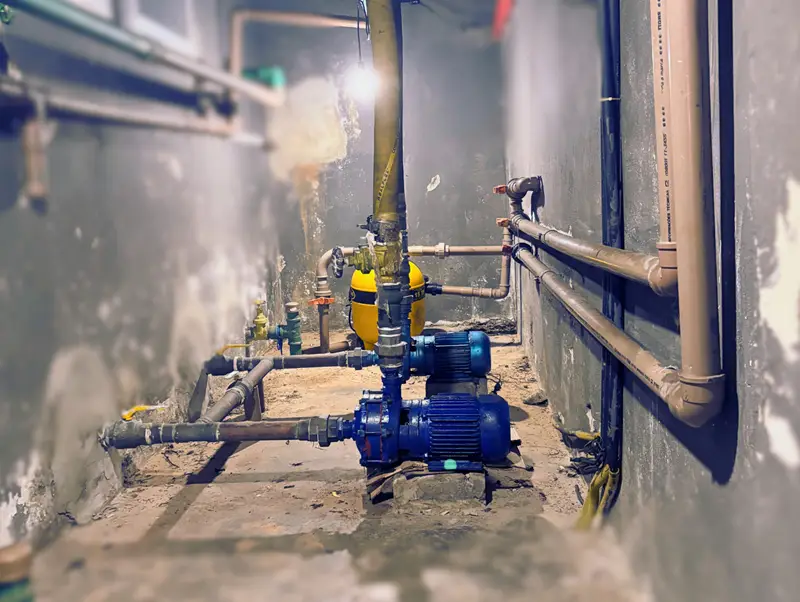 Sala técnica com duas bombas d’água conectadas à infraestrutura hidráulica.